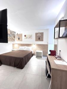 トルトリにあるLongevity Hotelのベッドルーム(ベッド1台、テレビ、デスク付)