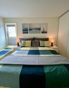 a large bed in a bedroom with two lamps at Experience a Cozy Getaway Near Pulpit Rock - B unit in Strand