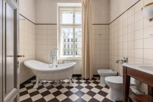 a bathroom with a tub and a toilet and a window at The Benjamin House in Rīga