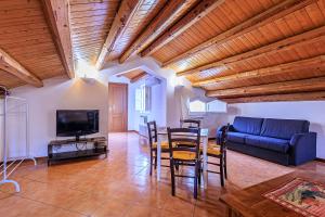 Una sala de estar con una mesa y un sofá azul. en Casa Querencia rooms, en Palermo