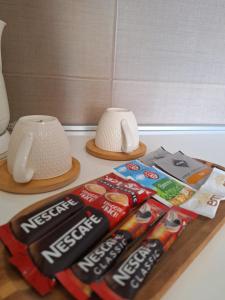 a table with a packet of coke and a vase and a pile at Garni Hotel Ema in Kragujevac