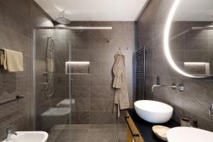 a bathroom with a shower and a sink and a mirror at Oberplunerhof Luxury Chalet Woods in Colli in Pusteria +33 photos