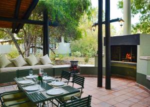 Un patio con mesa y sillas y una chimenea. en Burchell's Bush Lodge by Dream Resorts, en Reserva de caza Sabi Sand