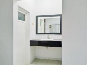 a bathroom with a sink and a mirror at RedDoorz near Alun Alun Kembangjoyo Pati in Pati +26 photos