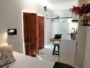 a small room with a kitchen and a table with a laptop at Melkbos Sea Spray Studio Apartment in Cape Town