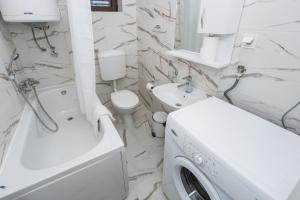 a white bathroom with a washing machine in it at Apartments Raymond in Sveti Stefan
