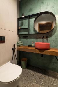 a bathroom with a red sink and a mirror at Luksusowy apartament Ryn Mazury Widok na Jezioro, Gorąca BALIA in Ryn