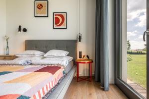 a bedroom with a bed and a table and a window at Luksusowy apartament Ryn Mazury Widok na Jezioro, Gorąca BALIA in Ryn