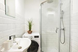 a white bathroom with a sink and a shower at Klimatyczne gniazdko przy Rynku in Wrocław +32 photos