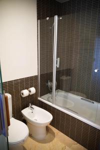 a bathroom with a toilet and a tub and a sink at Ohtels Les Oliveres in Perelló
