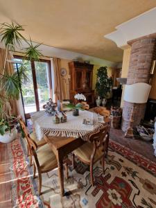 a living room with a table with chairs and a fireplace at Casa Delle Coccole in Trecastagni