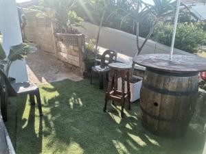 a patio with a table and chairs and a barrel at Oceans Black in Durban