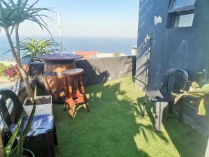 a small yard with a table and chairs and the ocean at Oceans Black in Durban