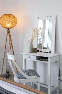 a white desk with a chair and a mirror at Eraora Lofts & Apartments Kefalonia in Lakithra