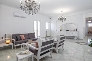 a living room with a chandelier and a table and chairs at Eraora Lofts & Apartments Kefalonia in Lakithra