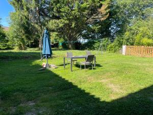 a table and chairs and an umbrella in a yard at Maison de la petite sorcière in Razac-de-Saussignac