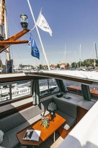 a table on a boat with a flag on it at Classic Yacht I Royal Cruiser 34 - "Barrel" in Klaipėda +33 photos
