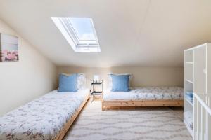 une chambre mansardée avec deux lits et une lucarne dans l'établissement Pedrógão Sea View, à Pedrógão