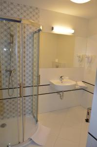 łazienka z prysznicem i umywalką w obiekcie Hotel Via Baltica w mieście Łomża