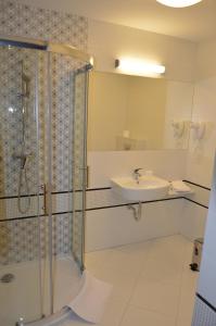 W łazience znajduje się prysznic i umywalka. w obiekcie Hotel Via Baltica w mieście Łomża