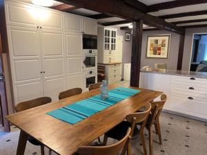 a dining room with a wooden table and a kitchen at Apartment in 1700s building in Södertälje