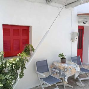 a table and chairs with a red door and a red window at Eutyxia House in Gaios Walk to Center & Beaches in Gaios