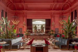 un restaurant avec des murs rouges, des tables et des chaises dans l'établissement Casa de las Artes, member of Meliá Collection, à Madrid