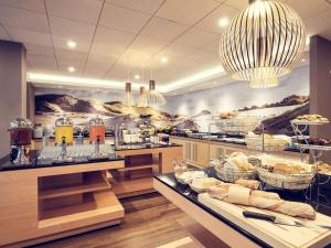 a restaurant with a buffet line with food on display at Mercure Gdańsk Posejdon in Gdańsk