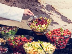 a person is serving fruit in bowls on a table at Mercure Gdańsk Posejdon in Gdańsk