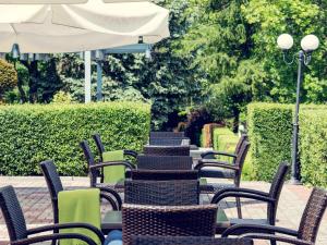 a row of tables with chairs and an umbrella at Mercure Gdańsk Posejdon in Gdańsk