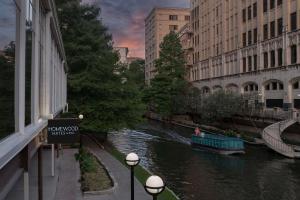 a boat on a river in a city with buildings at Homewood Suites by Hilton San Antonio Riverwalk/Downtown in San Antonio