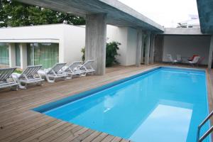 uma piscina num deque de madeira com cadeiras à volta em Casa do Castanheiro em Braga