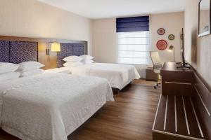 a hotel room with two beds and a window at Hampton By Hilton San Jose Airport Costa Rica in Alajuela City