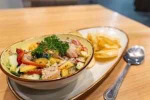 a bowl of food on a table next to a spoon at Hampton By Hilton San Jose Airport Costa Rica in Alajuela City