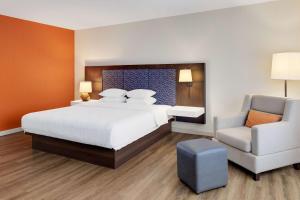 a bedroom with a large bed and a chair at Hampton By Hilton San Jose Airport Costa Rica in Alajuela City