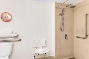 a bathroom with a shower and a toilet and a stool at Hampton By Hilton San Jose Airport Costa Rica in Alajuela City