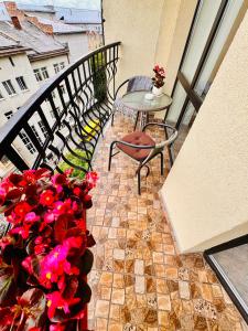 einen Balkon mit einem Tisch, Stühlen und Blumen in der Unterkunft Apartaments Sichovyh Strilciv 68a in Iwano-Frankiwsk