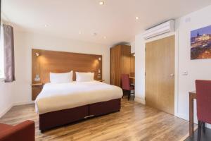 a hotel room with a bed and a desk at Holyrood Aparthotel in Edinburgh