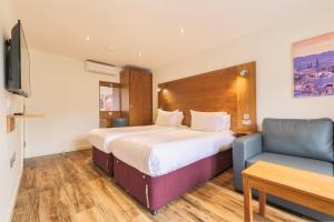 a hotel room with a large bed and a chair at Holyrood Aparthotel in Edinburgh