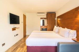 a hotel room with two beds and a flat screen tv at Holyrood Aparthotel in Edinburgh