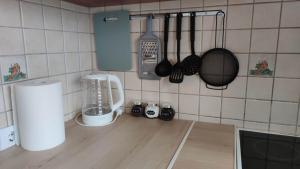 a kitchen counter with utensils on a tiled wall at Promenade Apartment in Liepāja