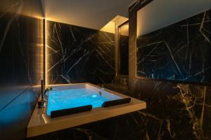 a bathroom with a blue tub and a mirror at Suite 26 Rimini in Rimini
