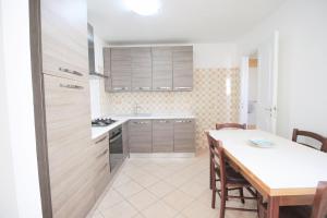 kuchnia ze stołem i jadalnią w obiekcie Graziella Apartments by RENTHOUSESALENTO w mieście San Foca +17 zdjęć