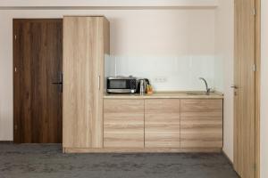 a kitchen with a microwave on a counter and a door at Svečių Namai TEN in Marijampolė