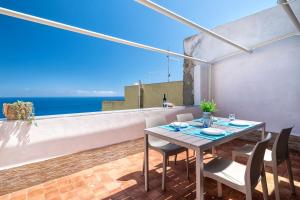 a table and chairs on a balcony with a view of the ocean at Magic Sea View Borgo Castelsardo in Castelsardo