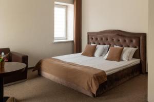 a bedroom with a large bed with a window at Svečių Namai TEN in Marijampolė