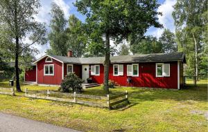 a red house with a fence in front of it at Amazing Apartment In Haverdal With Wifi in Haverdal