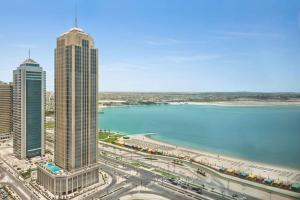 Wyndham Grand Doha West Bay Beach في الدوحة: اطلالة على مدينة فيها مباني طويلة وجسم ماء