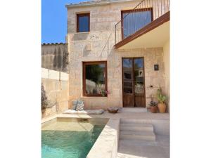a home with a swimming pool and a house at Ca na moltona in Ses Salines