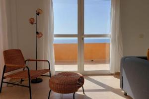 een kamer met een bed en stoelen en een groot raam bij La Marea Baja in Puertito de Güímar